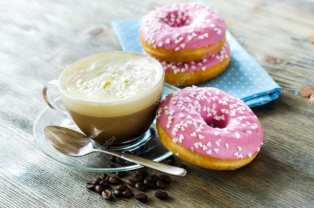 sweet food, pink doughnuts and cup of coffee with cream — stock