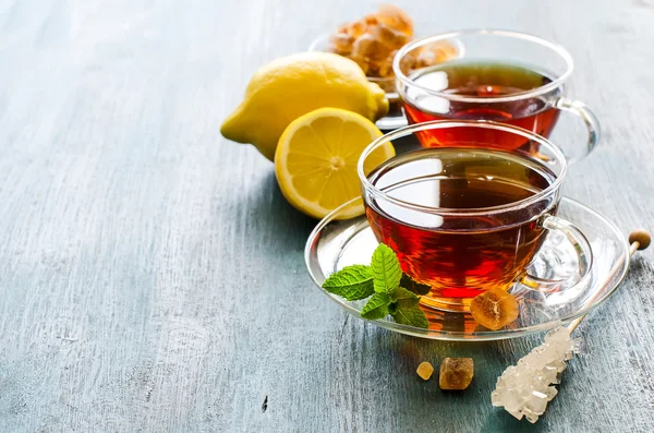 Cup of tea with mint leaf and chrystal sugar on dark rustic copy — Stock fotografie