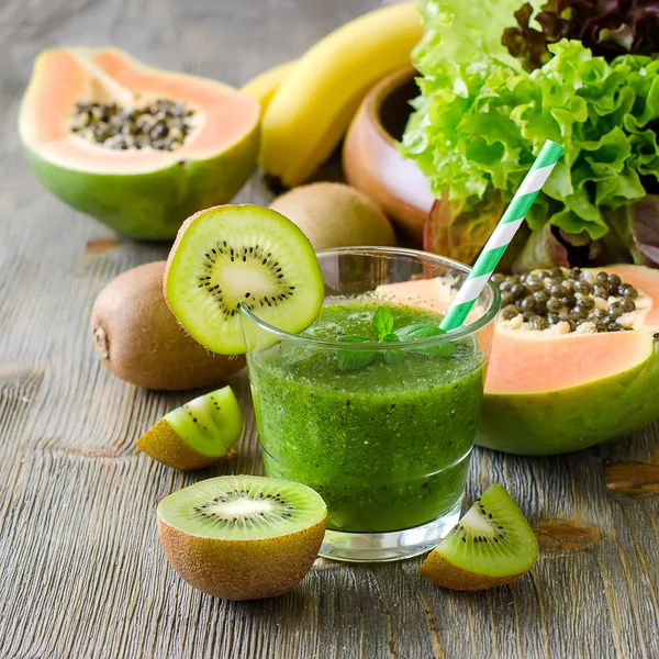 Smoothie tropical verde com kiwi, papaia e folhas de salada — Fotografia de Stock