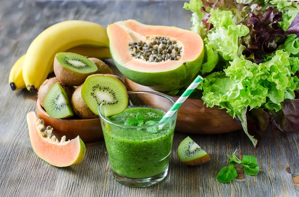 Green smoothie with kiwi, papaya and salad leaves