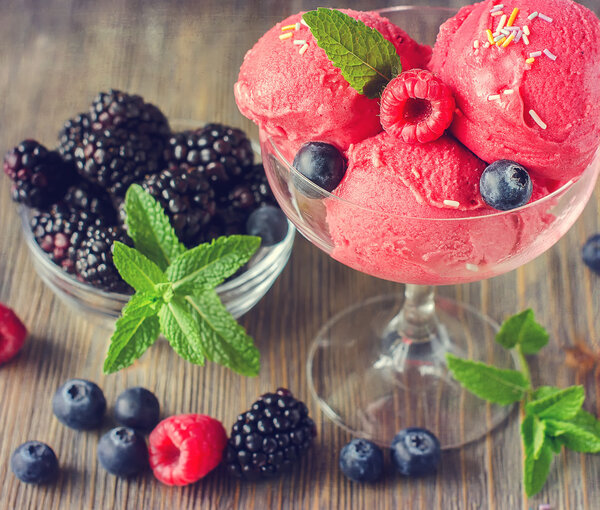 Red ice cream with raspberries, blackberries and blueberries, so