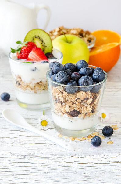 Здоровый завтрак с мюсли в стакане, свежие ягоды и йогурт
