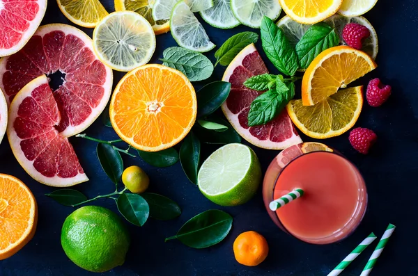 Fresh citrus slices and juice on black background top view — Stock Fotó