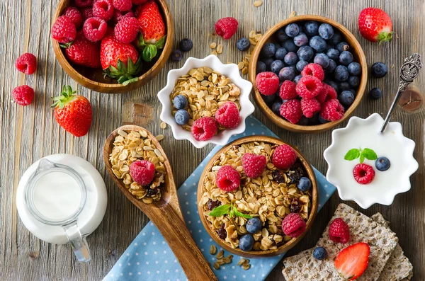 Свежий здоровый завтрак с мюсли и ягодами, витаминами, древесиной — стоковое фото