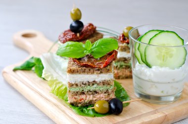 Rye granary bread sandwich with curd, antipasto, cucumber and ba