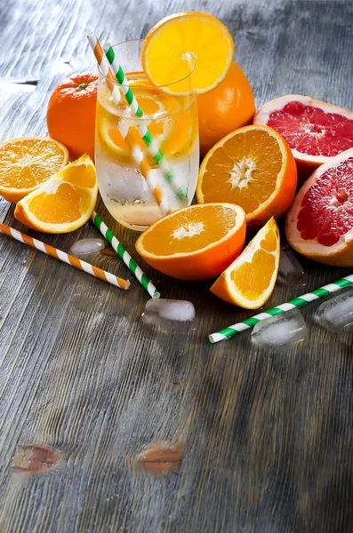 Naranja fresca y pomelos con vaso de agua y pajitas samp — Foto de Stock