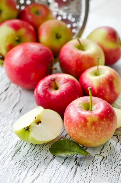 Pommes rouges fraîches du jardin avec des feuilles sur fond en bois — Photo