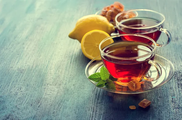 Tazza di tè con foglia di menta e zucchero crismale su dorso rustico scuro — Foto Stock