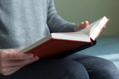 Genç adam kitap açıp okuyor. Kapalı, klasik tarzda.