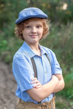 Yaz parkında palmiye ağaçlarıyla poz veren genç bir çocuk. Sevimli, gözlüklü, gülümseyen, 13 yaşında, kameraya bakan genç bir çocuk. Çocuğun açık hava portresi..