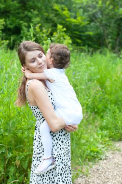 Mutlu anne ve çocuğu parkta birlikte oynuyorlar. Mutlu bir ailenin açık hava portresi.