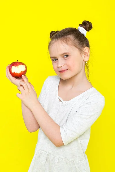 Niño feliz comiendo manzanas alimentos orgánicos saludables, niña con manzana roja, aislado. Hermosa niña comiendo fruta. El chico sostiene la manzana roja. Estudio. —  Fotos de Stock