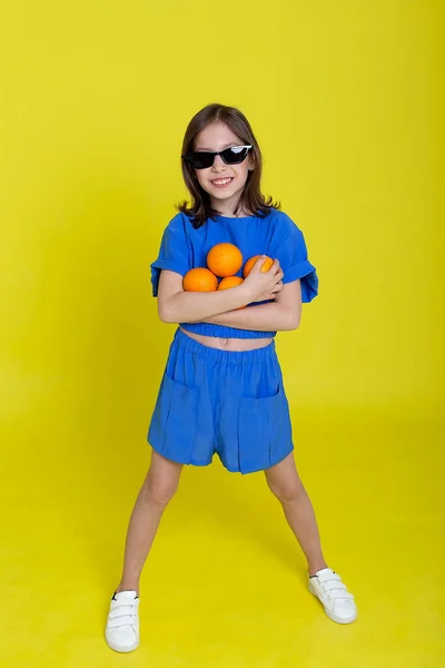 Bonito pouco brincalhão engraçado menina feliz segurando laranja laranjas, no fundo — Fotografia de Stock