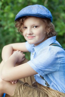 Yakışıklı bir genç adam kameraya bakar. Bir yaz gününde parkta gülümseyen güzel bir genç. Seyahat, yaz tatili, turizm, gençlik yaşam tarzı