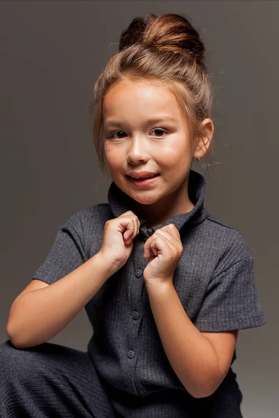 子供服 ジャケット レギンス 青い電車の中でかなり7歳の少女が暗い背景にポーズをとっています スタジオの写真 — ストック写真