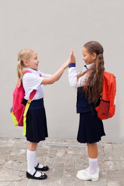 Pozitif ruh hali. Sırt çantalı genç kızlar parkta yürüyor. Okula dönelim. Sırt çantalı gençler. Arkadaşlık kavramı. en iyi okul arkadaşları. Eğlenerek okula gitmek. Sırt çantalı okul kızları.