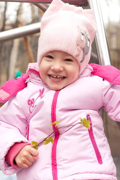 Ein süßes kleines Mädchen in Jacke und Hut mit Lähmung sitzt im Kinderwagen. Behinderungen. Spaziergänge im Freien — Stockfoto