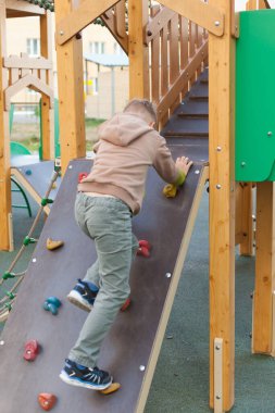 Sevimli, neşeli anaokulu çocuğu dışarıda oyun oynarken eğleniyor. Bahar, yaz ya da sonbahar çocuklar için aktif spor eğlencesi. Çocuklu aileler için açık hava aktiviteleri.