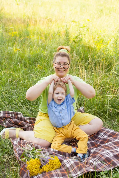 A mother and a little disabled boy hug and play in nature. Disability. Infantile paralysis. Mothers love. Happy childhood. — Stock Photo, Image