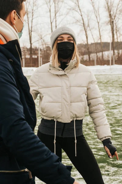 a group of masked athletes talking to each other. people in medical masks communicate on the street in winter