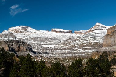 Ordesa y Monte Perdido Ulusal Parkı 'nda güneşli bir günde Taillon ve Casco tepeleri ile birlikte Rolando boşluğu ve parmak manzarası