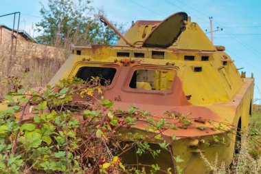 Dağlık Karabağ 'daki Arstakh Cumhuriyeti' nde içinde bitki örtüsü olan terk edilmiş bir savaş tankının önünde.