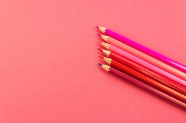 Pembe kalemler paralel olarak yerleştirilmiş ve yukarı doğru eğimli pembe arka plan üzerinde