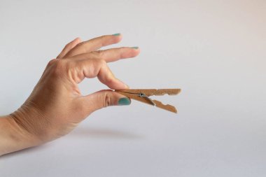 Beyaz arka planda açık mandalları tutan el.