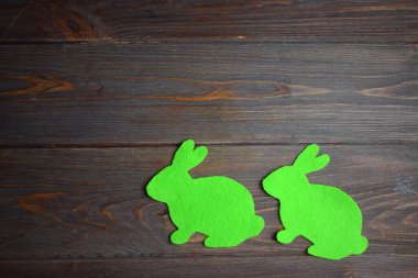 Tahta arka planda keçeli ve iplikli Paskalya tavşanı