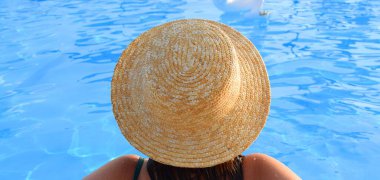 Havuzda hasır şapkalı bir kız. Tatil kavramı.