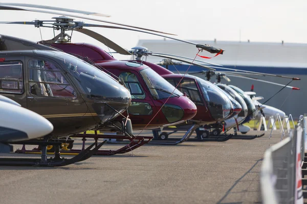 Helicópteros alinhados na pista ao lado um do outro durante a exposição. Sem logótipos . — Fotografia de Stock