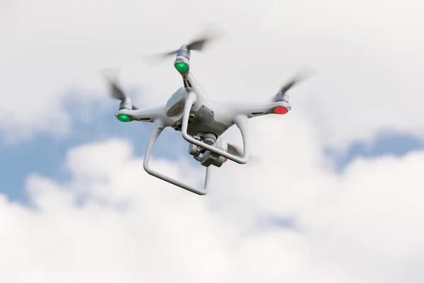 Drone blanco con luces, quadrocopter con cámara fotográfica volando en el cielo azul. Concepto —  Fotos de Stock