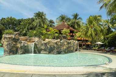 Kuta Beach palm coat, luxury resort with swimming pool. Bali, Indonesia clipart