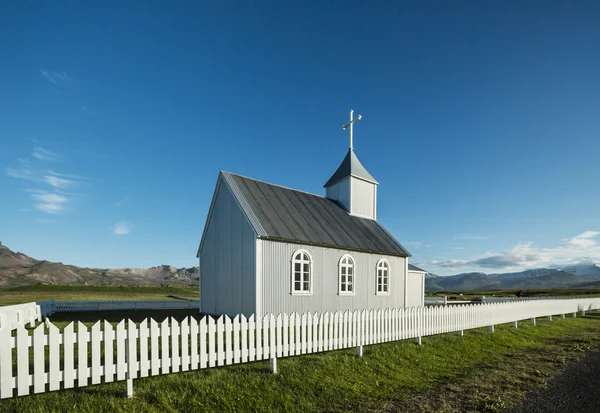 Typisk Landlig Islandsk Kirke under en blå sommerhimmel. - Stock-foto