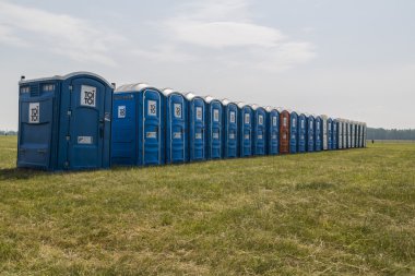 Long row of mobile toilets clipart