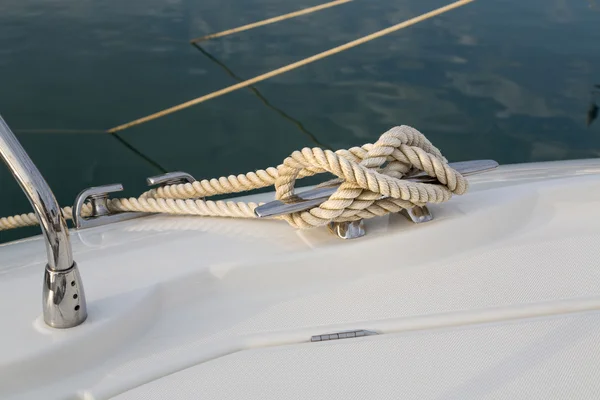 Cuerda de nudo náutico de primer plano atada alrededor de la estaca en el barco o barco, cuerda de amarre del barco — Foto de Stock