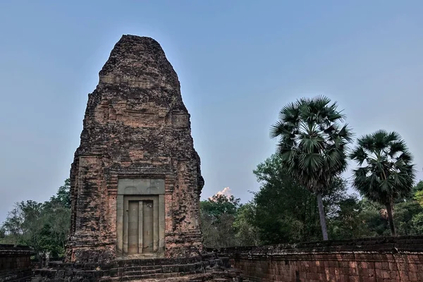 在夜空的背景下 古老的吴哥寺的破塔 红砖的台阶和墙壁被时间损坏了 丛林里的棕榈树柬埔寨 — 图库照片