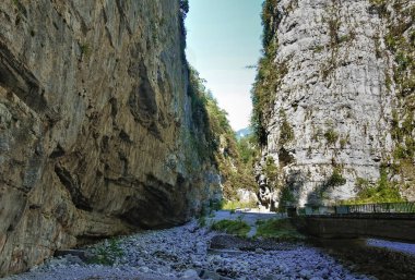 Yol uçurumun içinden, dik kayalıkların arasından geçiyor. Köprü kurumuş, çakıllı bir nehir yatağının üzerine kuruludur. Yaz güneşli bir gün. Yupshar Kanyonu 