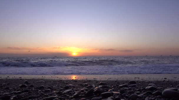 Закат Морские Волны Катятся Пляжу Пена Распространяется Блестящей Гальке Солнце — стоковое видео