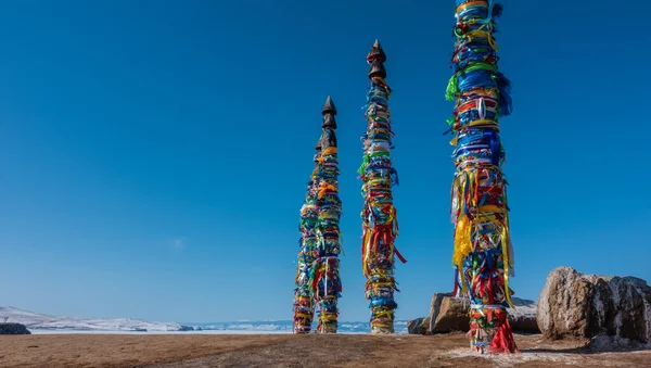 Деревянные Высокие Столбы Стоящие Ряд Связаны Разноцветными Ритуальными Лентами Рядом — стоковое фото