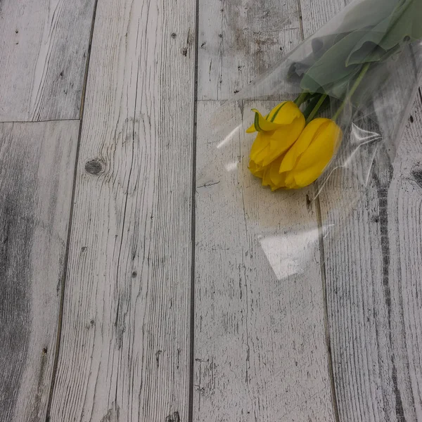 Três Tulipas Amarelas Envoltório Presente Transparente Flores Estão Deitadas Tábuas — Fotografia de Stock