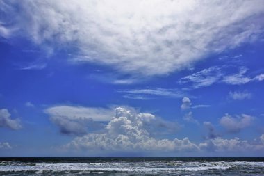 Okyanus üzerinde fantastik bulutlar. Gök kubbede resim şeklinde kümülüs ve sirrus bulutları var. Dalgaların üzerinde beyaz köpük. Sri Lanka.