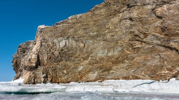 奇形怪状的花岗岩岩石没有植被 屹立在结冰的湖上 光秃秃的石头上有裂缝 底部被冰覆盖着 冬日阳光明媚 贝加尔湖 — 图库照片