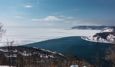Angara Nehri 'nin dondurucu olmayan kaynağı. Baykal Gölü buzu ile nehrin mavi suyu arasındaki sınır. Karlı ve ağaçlık kıyılar. Gökyüzüne karşı dağlar. Dinle beni.