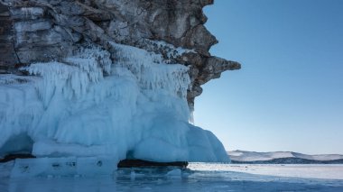 Garip ve gökyüzüne karşı hatları olan granit bir kaya. Dağ donmuş bir gölün üzerinde yükselir. Taban buz saçakları ve buz parçalarıyla kaplı. Baykal.
