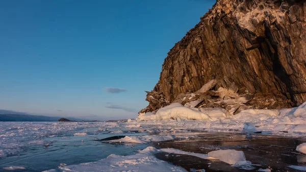 青い空を背景に 植生のない気まぐれな岩 純粋な花崗岩の斜面や凍った湖の氷の上に雪 表面への反射 夕方黄金の時間 バイカル — ストック写真