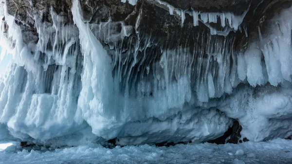 花崗岩の基盤はレースのような空想のつららで覆われています 凍った湖の表面に氷の破片 接近中だ フルフレーム バイカル — ストック写真