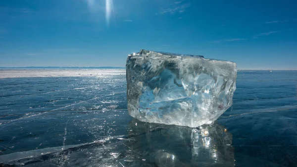Ein Transparenter Eiskristall Liegt Auf Der Glatten Blauen Oberfläche Eines — Stockfoto