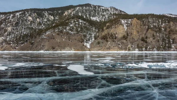 Frozen Lake Patterns Intersecting Cracks Snow Shore Wooded Mountains Reflection — Stock Photo, Image