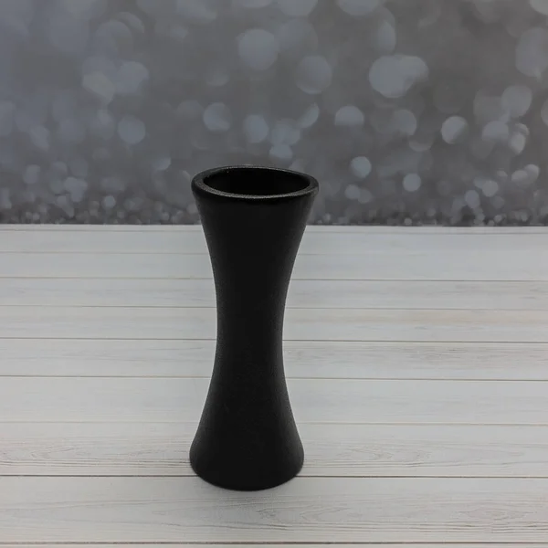 木製のテーブルの上には陶器の黒い花瓶が立っている 優雅な砂時計のようなシルエット 灰色の背景 — ストック写真
